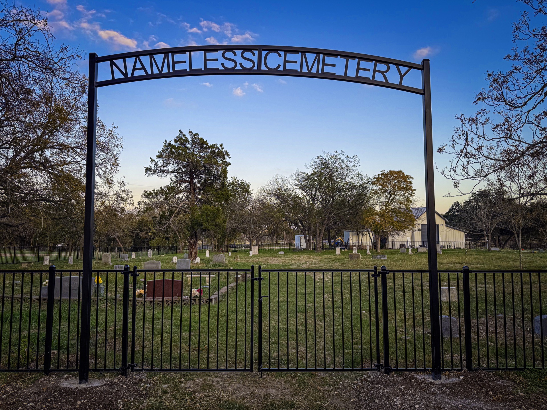The iron gate arch of Nameless Cemetery with the cemetery name forged into the arch