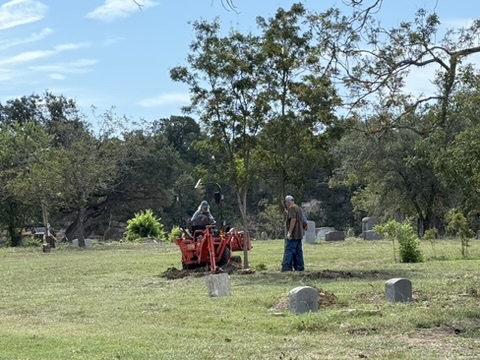 Volunteer working alongside a tractor at Nameless Cemetery